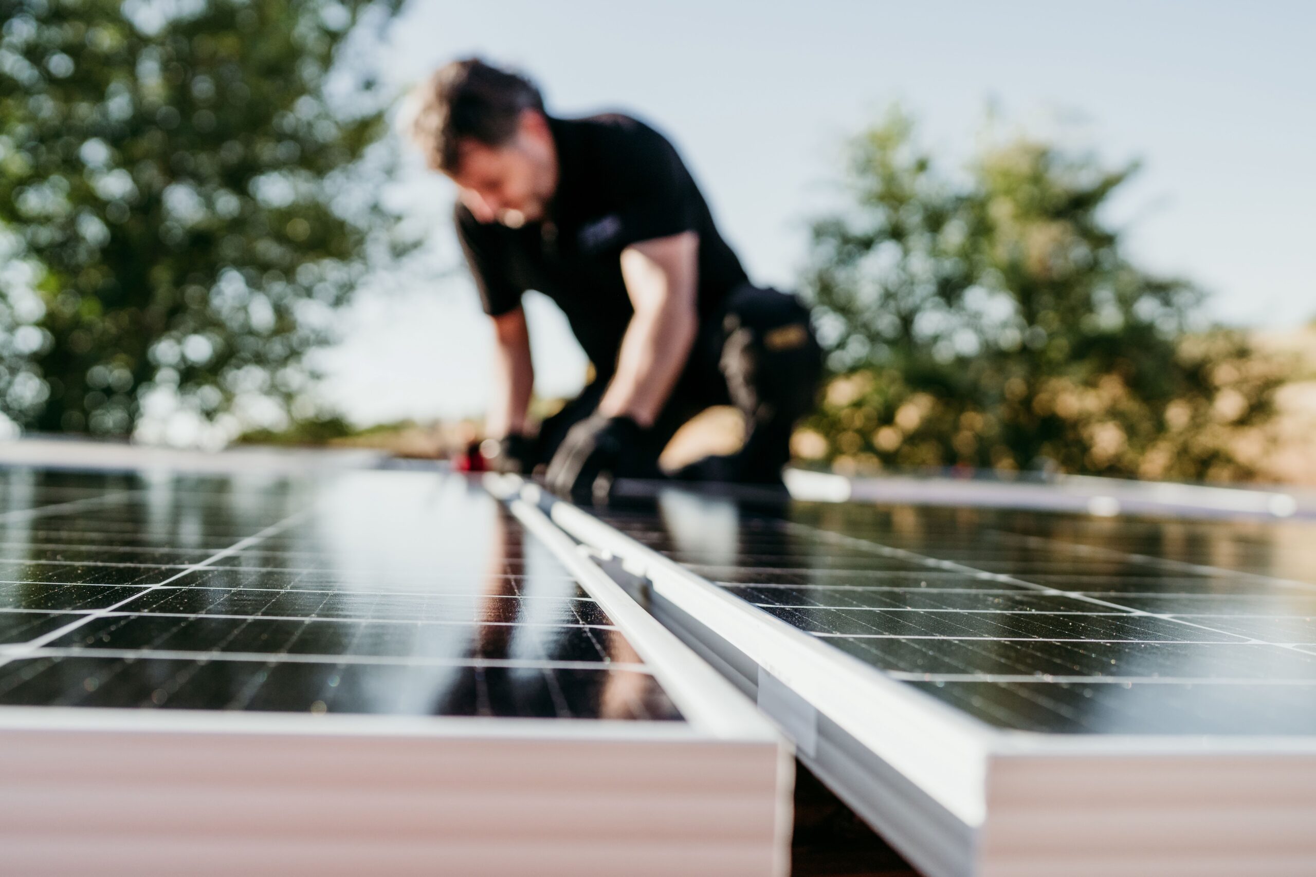 Eine Person verlegt eine Solaranlage auf einem Haus 